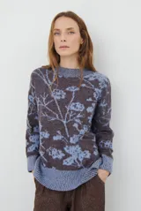 Buzo de tejido de punto con cuello redondo, mangas largas con puños acanalados y diseño estampado de flores en tonos rojos.