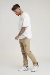 Pantalón cargo color beige, de corte recto y tiro medio, con bolsillos laterales con solapa y botón.