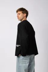 Sweater de punto liviano color negro con textura marcada, diseño de cuello redondo y calce holgado.