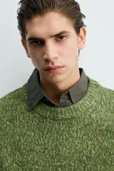 Jersey de punto con estructura de torzal y efecto jaspeado, de corte relajado, cuello redondo y manga larga con acabados en rib.