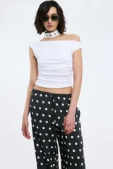 Pantalón negro de viscosa con estampado de lunares blancos, cintura elastizada con lazo regulable y pierna recta.