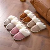Pantufla cerrada de gamuza gris con interior y borde de peluche blanco, suela de goma antideslizante.