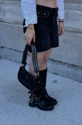 Cartera baguette color borgoña con correa corta con tachas plateadas.