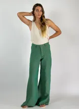 Pantalón de lino azul de corte palazzo, tiro alto y pierna ancha. Presenta costuras a la vista en color blanco y botón metálico.