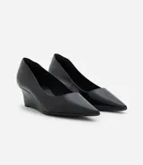 Zapato estilo scarpin con taco anabela de 5 cm, confeccionado en poliuretano con acabado liso y punta fina. Diseño minimalista y cerrado, ideal para uso diario o formal.