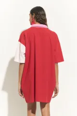 Túnica de algodón con diseño bicolor en bloques diagonales rojos y blanco off-white, con cuello camisero, botonera central y mangas cortas en contraste de color rosado.