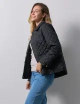 Campera capitoneada color beige, marca Weatherproof, con cuello con solapa, abertura central con botones metálicos, bolsillos delanteros y forro interno a tono.