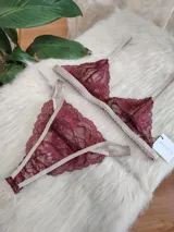 Conjunto de lencería compuesto por un bralette triangular de encaje con breteles regulables y una tanga colaless regulable con detalles de encaje y entrepierna de algodón.