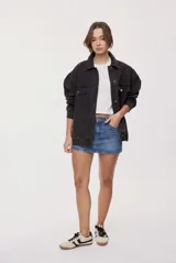 Minifalda de denim de tiro medio y calce ajustado. Presenta bolsillos delanteros con tachas metálicas aplicadas a lo largo de los bordes y cierre frontal con botones.
