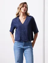 Blusa blanca de lyocell con escote en V y mangas cortas.