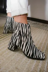 Botas plateadas de cuero con caña media, cierre lateral con cremallera, punta cuadrada y tacón geométrico de madera.