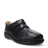 Zapato casual de cuero negro con cierre de doble tira de velcro, diseñado para brindar comodidad y soporte, con suela ergonómica y costuras reforzadas.