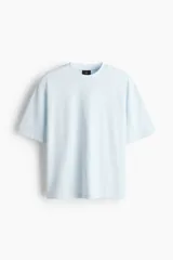 Remera de algodón en punto pesado, color celeste, de corte boxy, cuello redondo ribeteado, hombros caídos y mangas cortas.