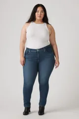 Pantalón de jean azul oscuro, tiro medio, corte ajustado y largo hasta el tobillo.