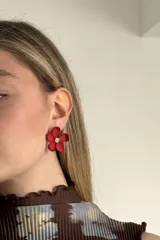 Aros de mujer con diseño de flor roja y centro dorado.