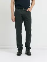 Pantalón de algodón sarga con elastano, diseño de cinco bolsillos, cierre frontal con botones de metal en tono plata viejo y bolsillos traseros de parche.