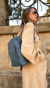Mochila de diseño estructurado en color bordó, confeccionada en símil cuero con costuras decorativas en forma de rombos en el frente. Cuenta con un bolsillo frontal con cierre, asa superior de mano y correas regulables.