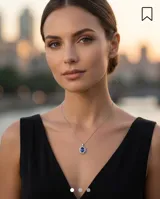 Collar de cadena fina de plata 925 con dije colgante en forma ovalada, compuesto por una piedra central de zafiro rodeada por pequeñas circonias brillantes.