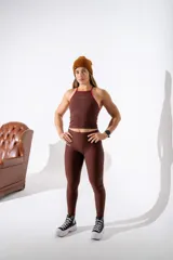 Calza deportiva de tiro alto color marrón, confeccionada en tejido técnico elástico con ajuste ceñido al cuerpo.