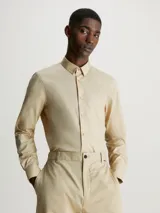 Camisa de vestir color beige, de corte slim, con cuello clásico y cierre frontal con botones.