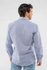 Camisa de manga larga con diseño de cuadros en tonos azules, blancos y negros. Presenta cuello clásico, cierre frontal con botones y logo bordado en el pecho. Corte semi slim.