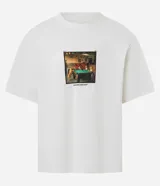 Remera de algodón color blanco, corte boxy, manga corta y cuello redondo. Presenta una estampa fotográfica localizada en el pecho de varios perros jugando al billar sobre una mesa verde.