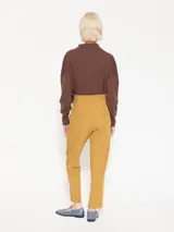 Pantalón negro de vestir con corte recto, tiro alto y cinturón con hebilla metálica. Presenta bolsillos laterales y traseros.