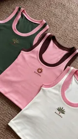 Musculosa de rib con elastano, escote redondo y sisas ribeteadas en contraste, con diseño bordado en el pecho.