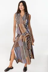 Falda midi de algodón, con diseño geométrico de paneles con rayas verticales en tonos marrón, celeste, blanco y negro. Presenta pretina elastizada en la parte trasera y silueta evasé.