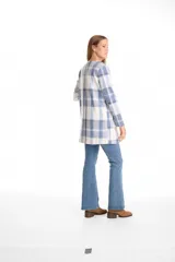 Cardigan abierto de tejido soft con estampado de cuadros en tonos azul y blanco. Presenta corte recto, mangas largas y dos bolsillos frontales aplicados.