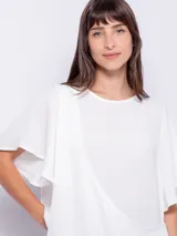 Top rosado de mangas cortas con volados, cuello redondo y detalle diagonal en el frente.