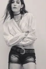 Short de denim negro con efecto desgastado, diseño de tiro bajo y dobladillo deshilachado.