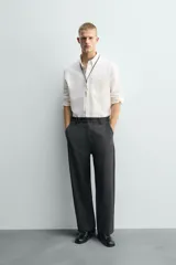 Pantalón de corte carrot fit confeccionado en tejido con mezcla de viscosa. Presenta bolsillos frontales, bolsillos traseros de vivo y cierre frontal con cremallera y botones.