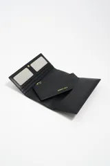 Billetera de estructura rígida color negro con logo metálico dorado de la marca Bimba y Lola en el frente. El interior cuenta con tarjetero y monedero con cierre de cremallera.