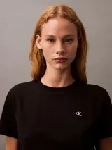 Remera de cuello redondo Calvin Klein, confeccionada en algodón regenerativo. Presenta un diseño minimalista de corte regular con mangas cortas y el logo monograma de la marca bordado en el pecho.