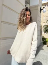 Sweater de punto en color crudo, con diseño oversize, cuello redondo y mangas largas. Presenta una textura suave y caída holgada.