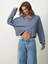 Buzo manga larga color celeste con diseño irregular y corte crop.