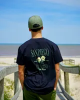Remera negra de corte clásico, con estampado en la espalda con el texto "San Diego", flores y "California Tribe Brand".