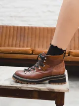 Borcego de cuero negro con cordones y suela track color caramelo.