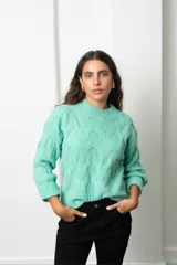 Buzo de tejido de punto con diseño de ochos, cuello redondo y mangas largas con puños acanalados.