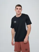 Remera deportiva Umbro modelo Vant, de color negro con paneles laterales grises y cuello redondo, diseñada para hombre.