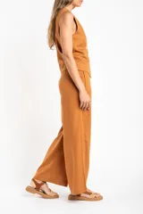 Pantalón de lino color tostado, de corte recto y tiro medio.