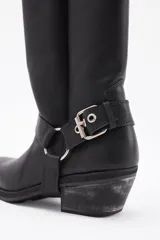 Bota de cuero marrón con caña alta y estribo desmontable.