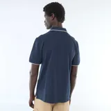 Remera polo de piqué color azul marino con detalles blancos en el cuello y los puños, cierre frontal con botones y pequeño logo bordado en el pecho.