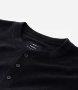 Camisa de pijama de manga larga confeccionada en tejido plush color negro, con cuello redondo y cierre frontal parcial con botones.