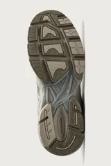 Zapatilla deportiva tipo running color marrón, con parte superior confeccionada en combinación de piezas de malla, gamuza y material sintético. Posee suela con volumen y diseño irregular.