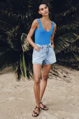 Shorts de denim de tiro medio, corte mom fit, con cinco bolsillos y cierre frontal con cremallera y botón, en color azul lavado.