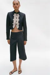 Bermuda larga de tiro alto en tejido de denim azul oscuro, con diseño de pernera recta y ancha, y detalles de botones metálicos dorados en la parte delantera.