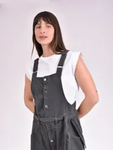 Monoprenda larga de denim gris oscuro, con diseño estilo overall, tirantes ajustables, cierre frontal de botones metálicos y bolsillos frontales grandes. Incluye un cinturón ajustable del mismo material.