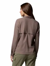 Camisa de trekking Columbia de manga larga, color marrón, con cuello clásico, cierre frontal de botones y bolsillo en el pecho con logo de la marca. Diseño técnico con tecnología Omni-Shade y Omni-Wick.